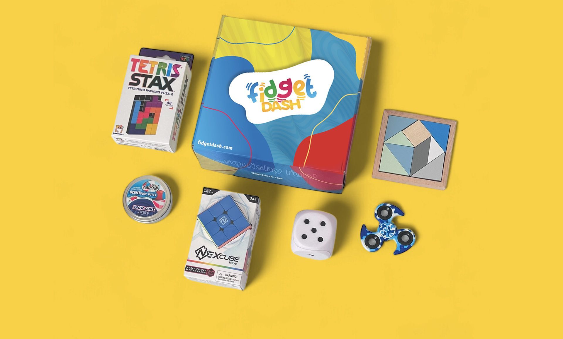 A fidget dash box filled with sensory toys and games on a yellow surface.