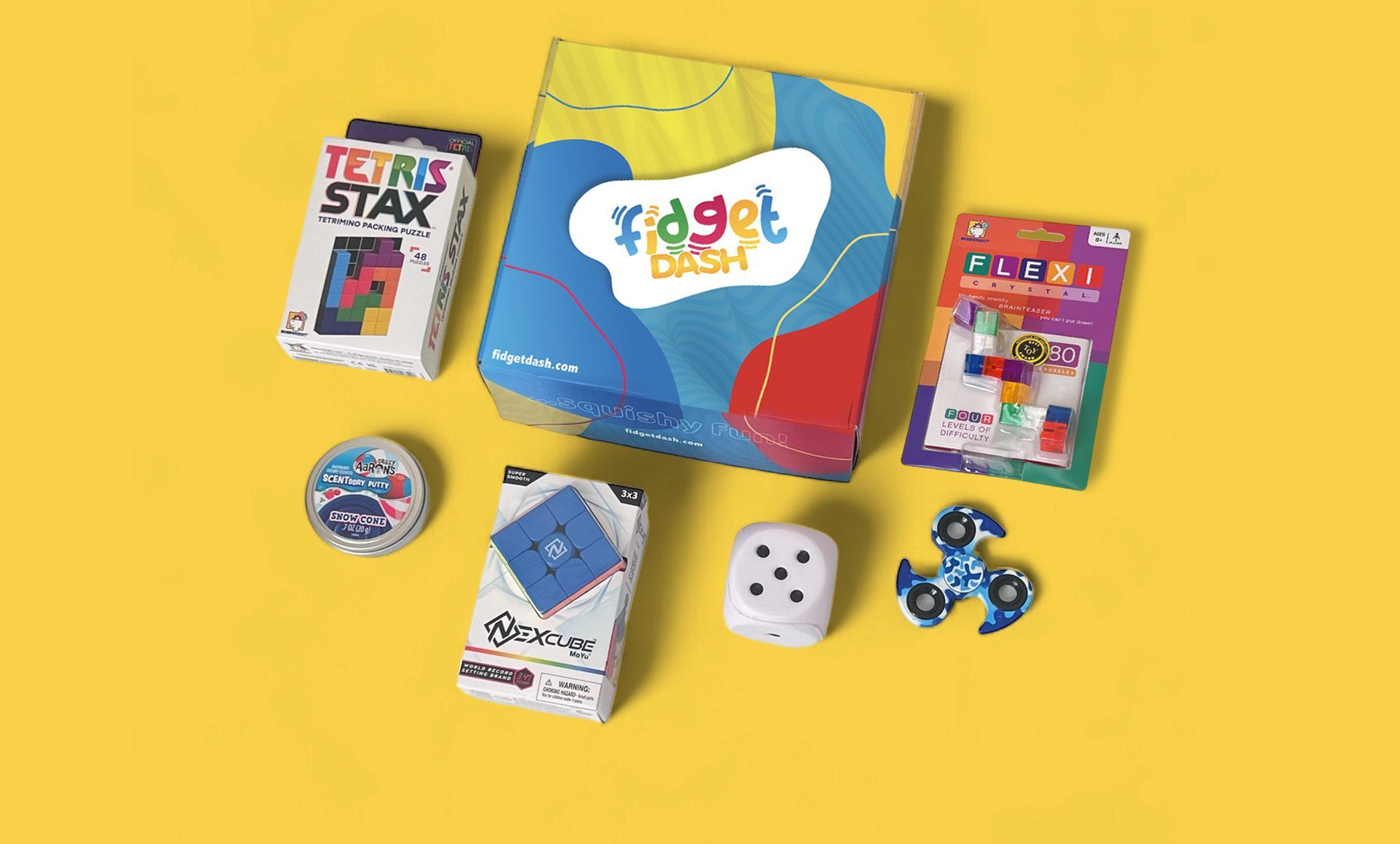 A fidget dash box filled with sensory  toys and games on a yellow surface.