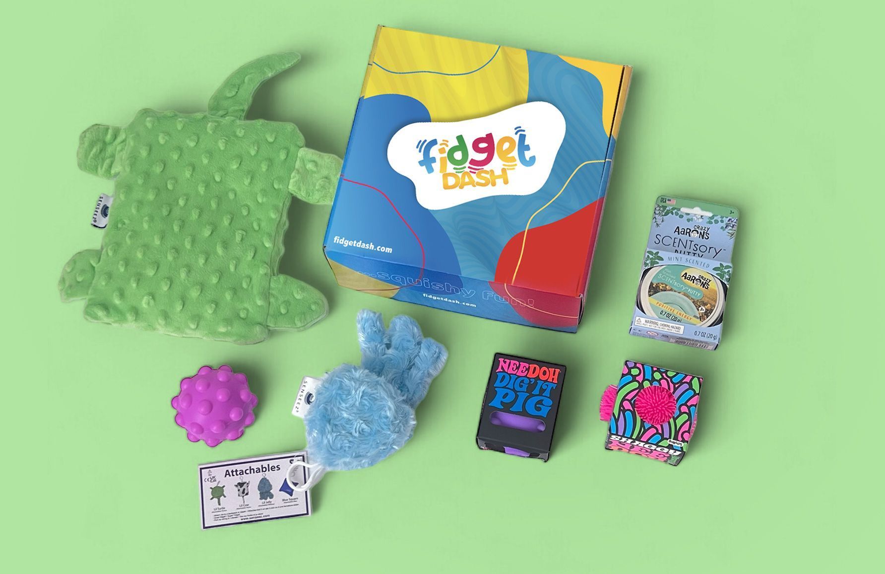 A fidget dash box of sensory  fidget toys is sitting on top of a green table.