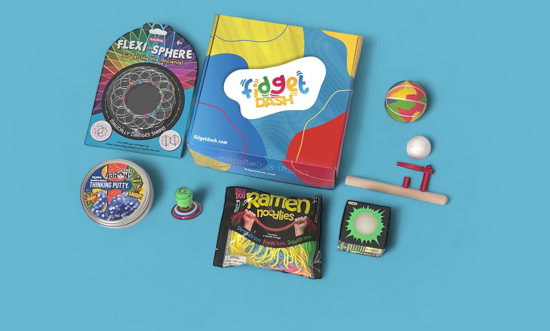 A fidget dash box with a bunch of sensory  toys are sitting on a blue surface