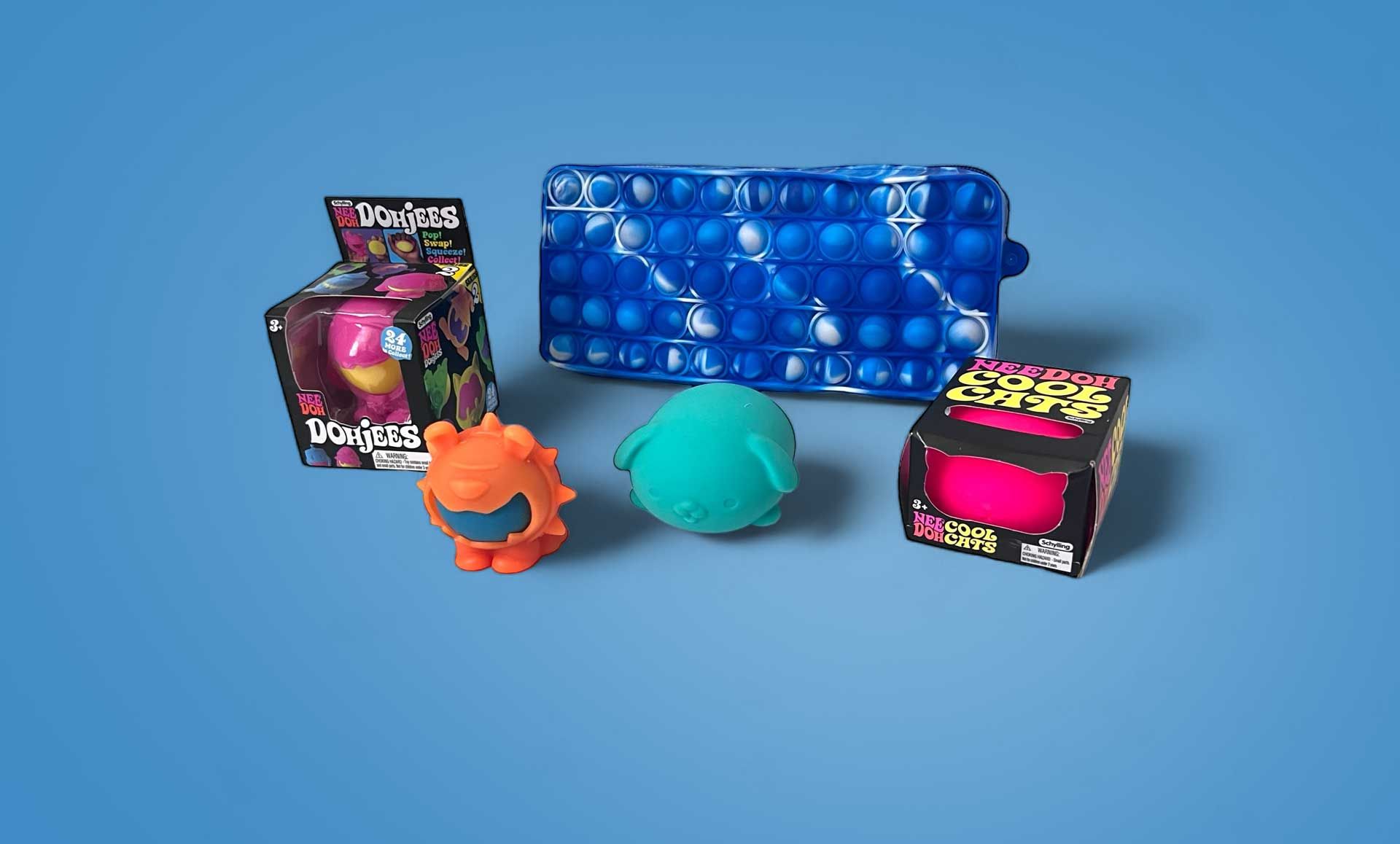 Various colorful fidget toys displayed on a blue surface.