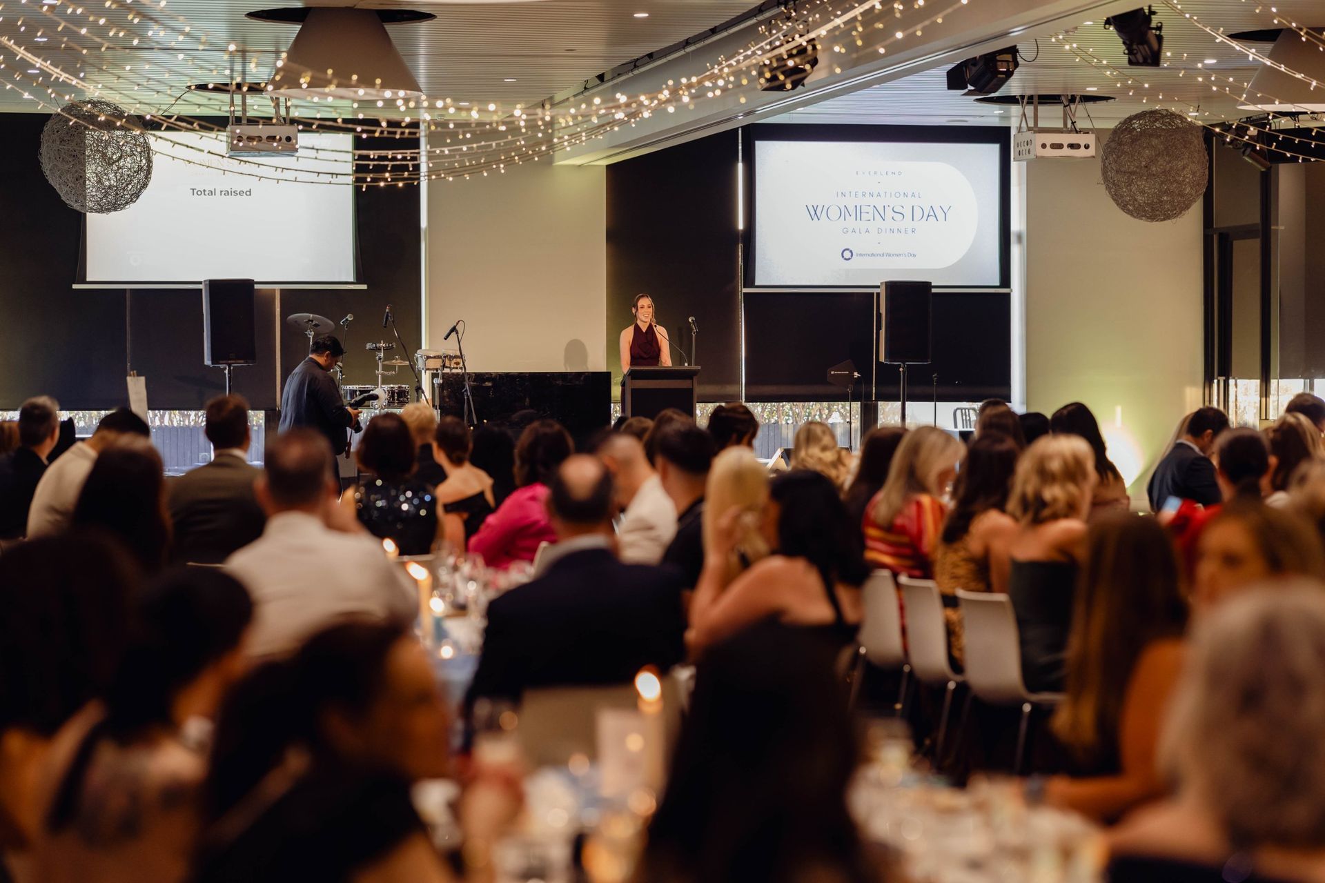 Guests seated for dinner as a speaker addresses the room at the EverLend International Women's Day Charity Gala