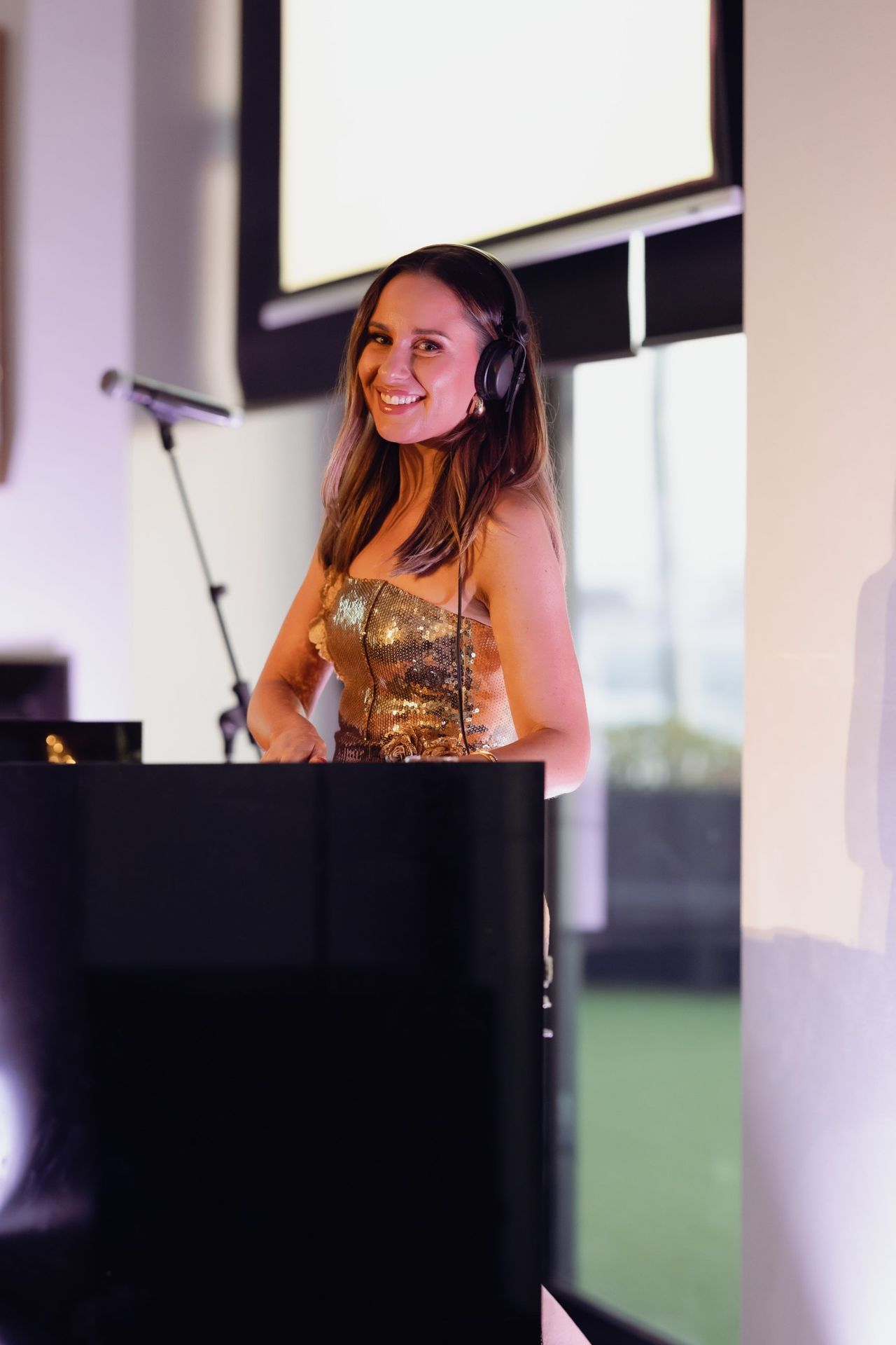 DJ smiling behind the decks at the EverLend International Women's Day Charity Gala