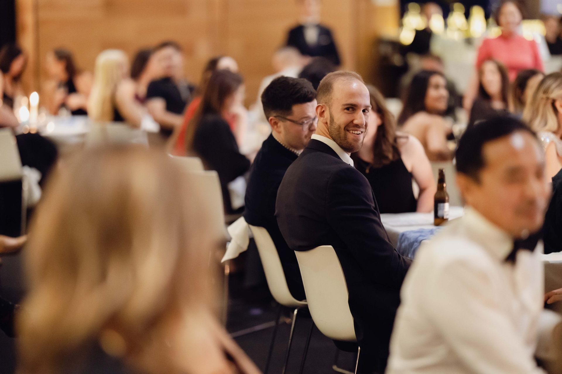 Guest smiling at a dinner table at the EverLend International Women's Day Charity Gala