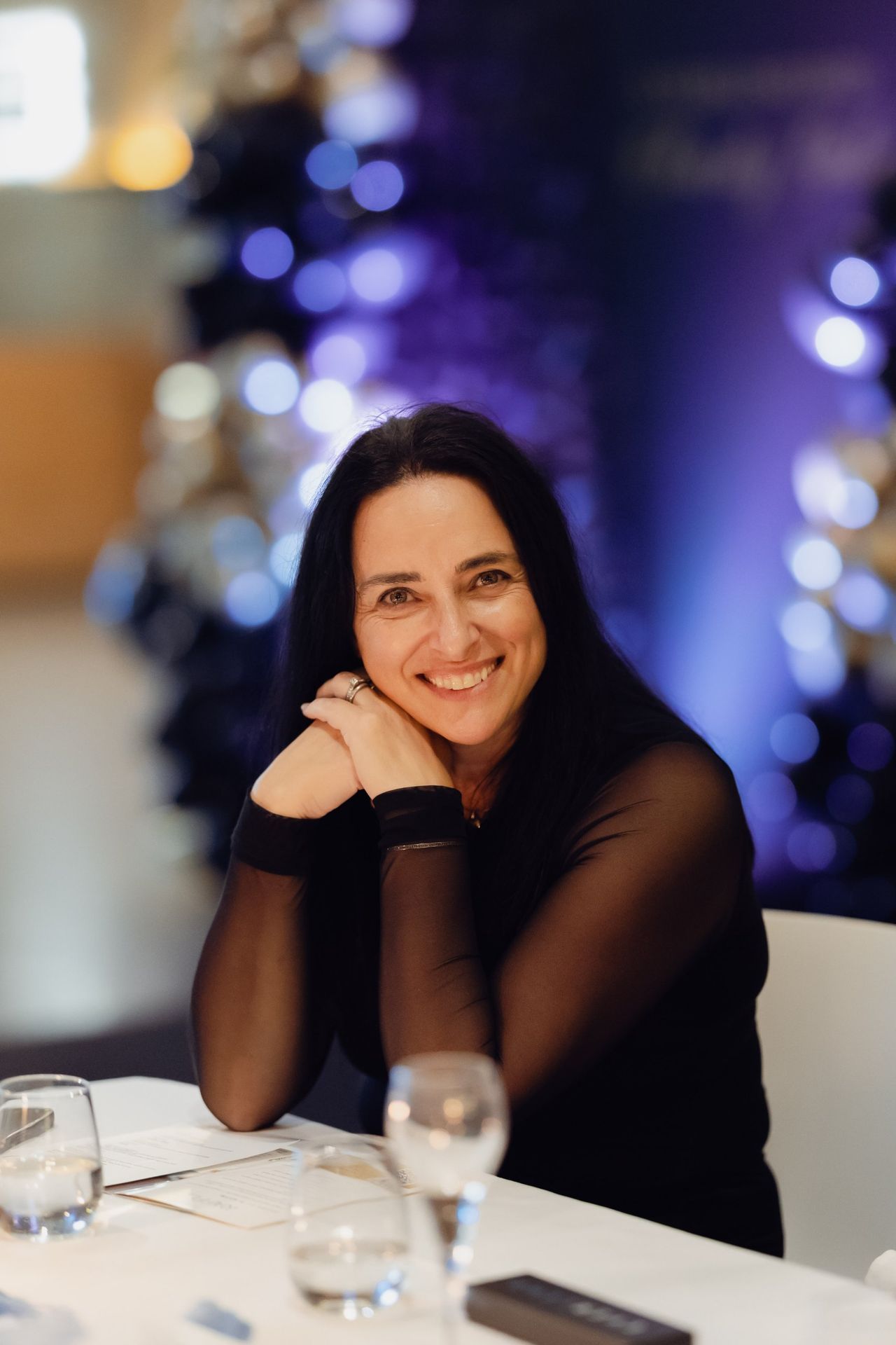 Guest smiling at her table at the EverLend International Women's Day Charity Gala