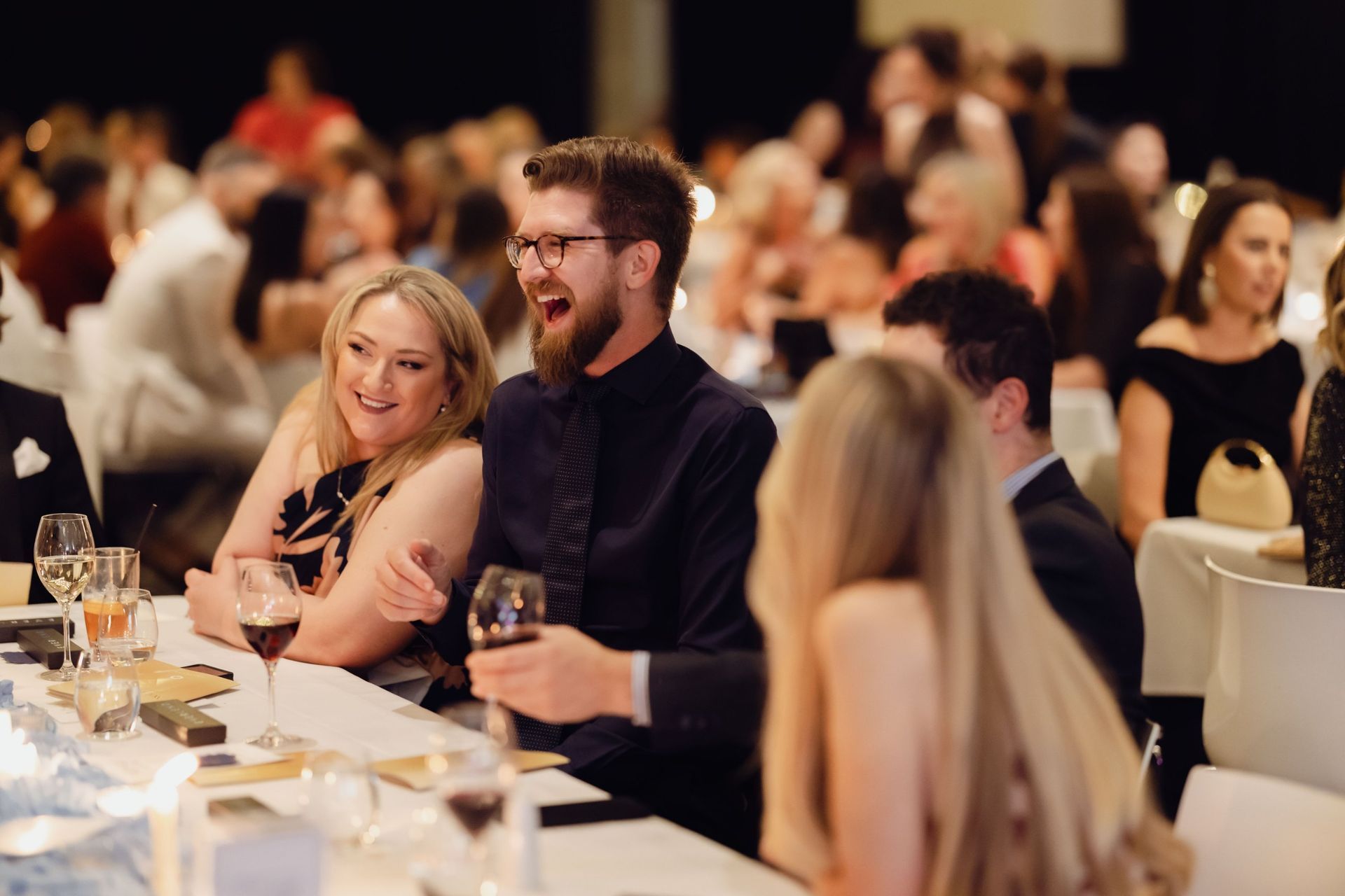 Guests laughing at their table at the EverLend International Women's Day Charity Gala