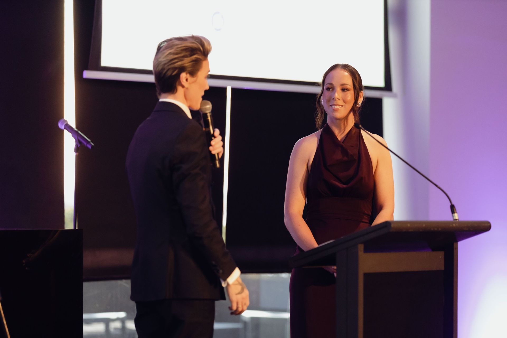 Host and speaker on stage at the EverLend International Women's Day Charity Gala