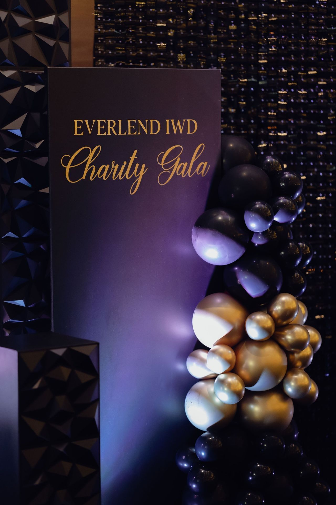 EverLend IWD Charity Gala sign with black and gold balloons