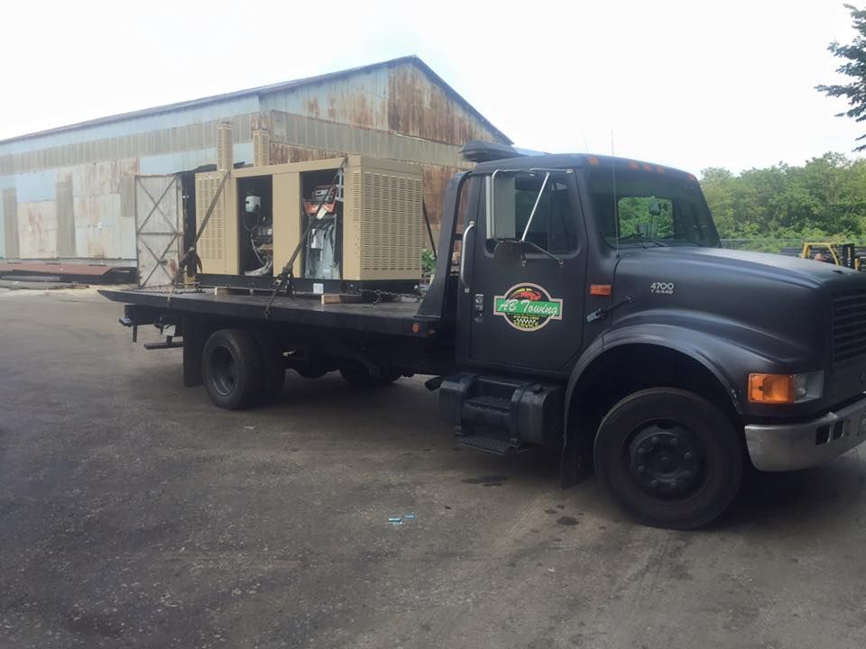 A black tow truck is parked in front of a building