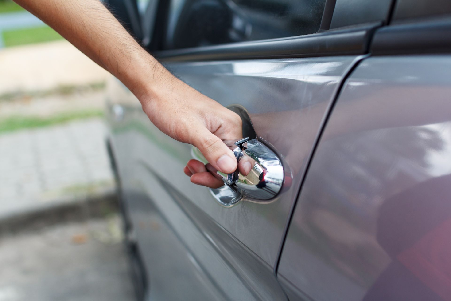 A person is opening the door of a car.