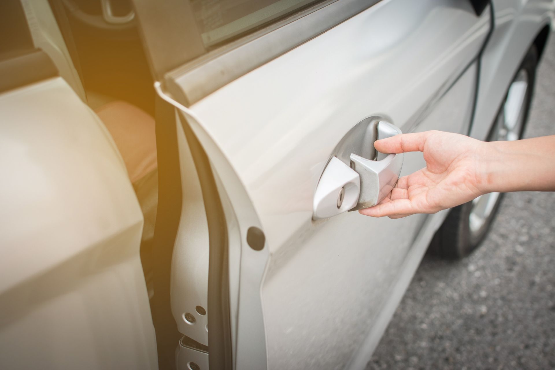 A person is opening the door of a car.