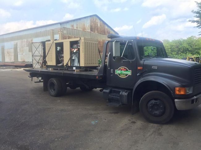 A black tow truck is parked in front of a building