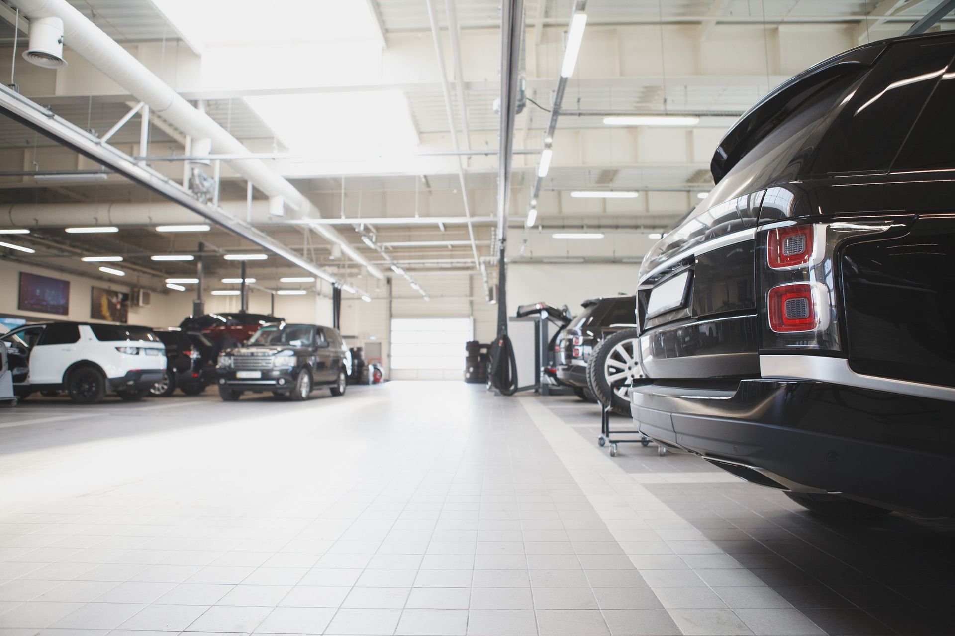 A row of cars are parked in a garage.