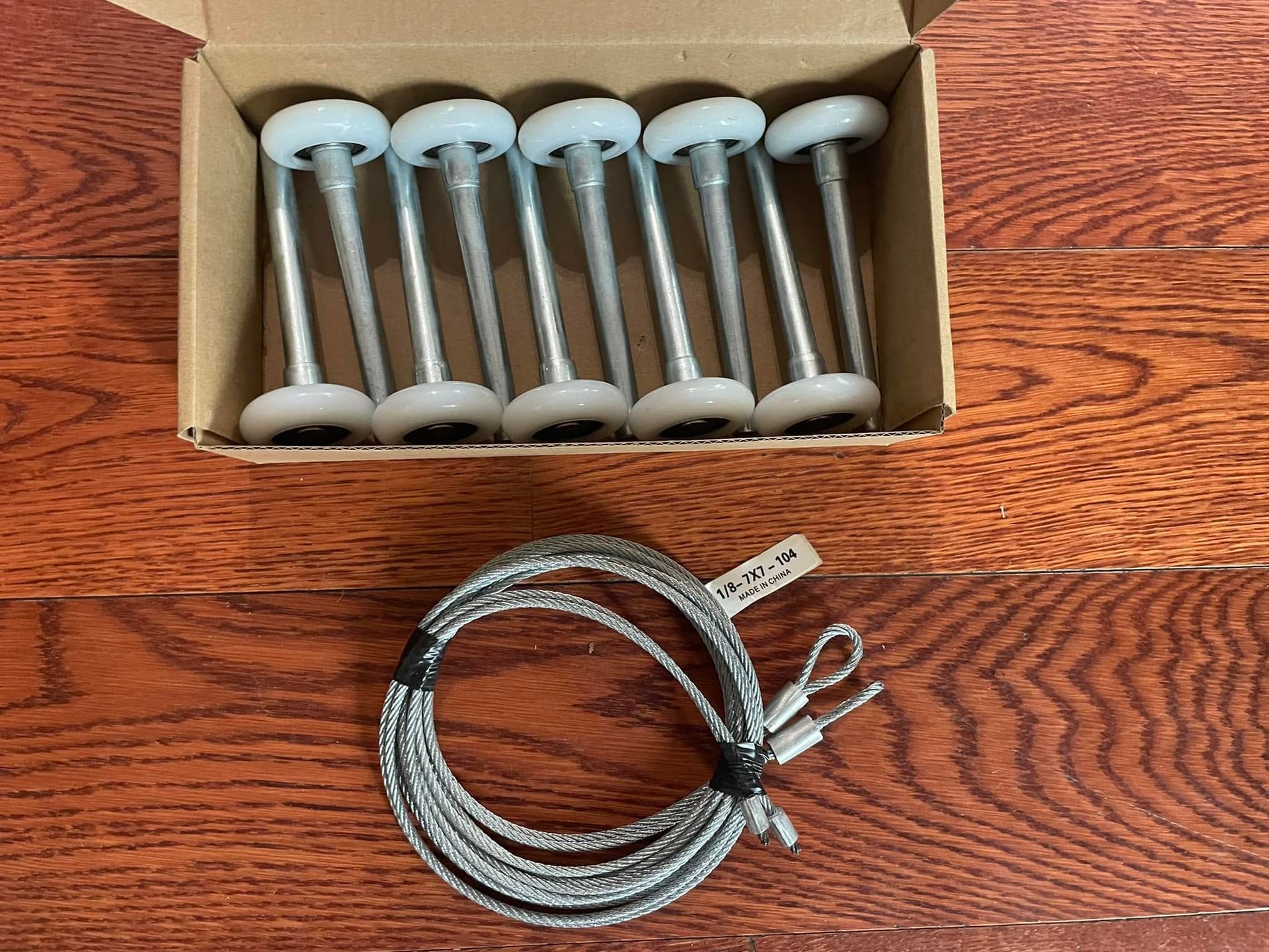 Replacement garage door rollers and steel lift cables ready for winter garage door maintenance