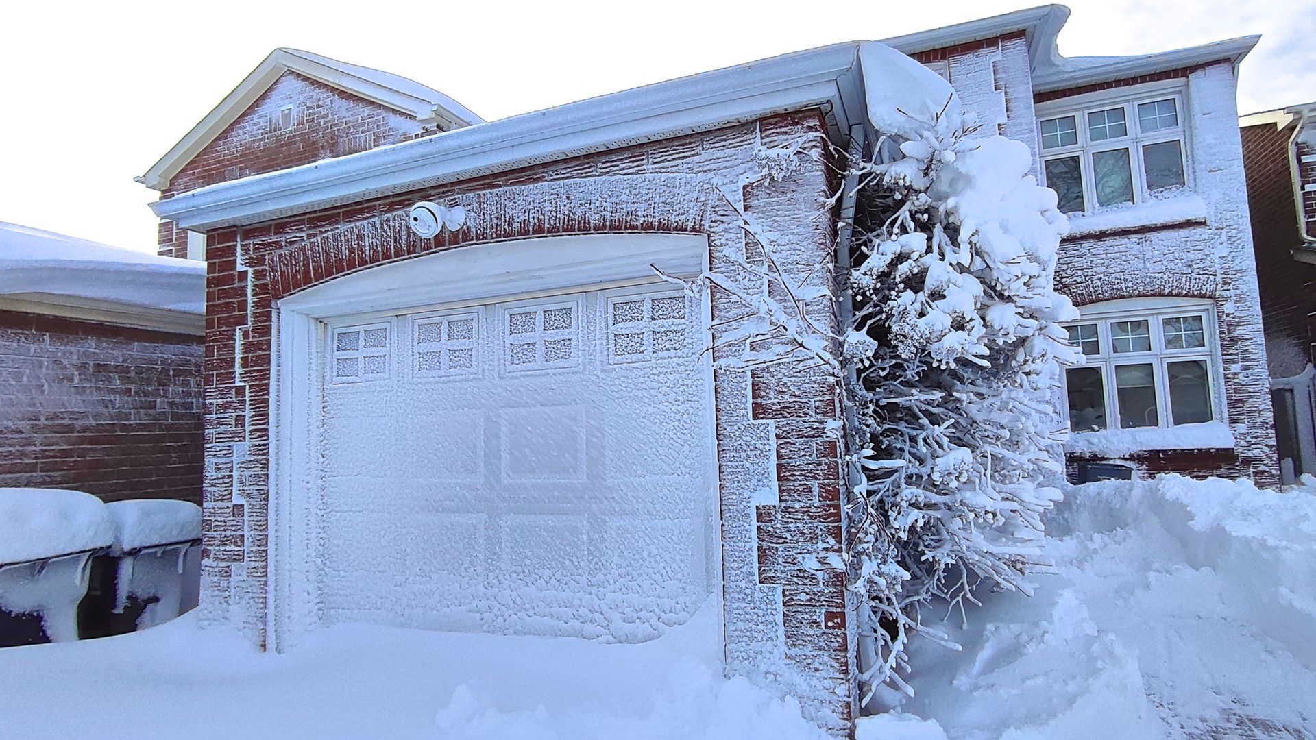 Snow-covered suburban house and garage after a heavy snowfall