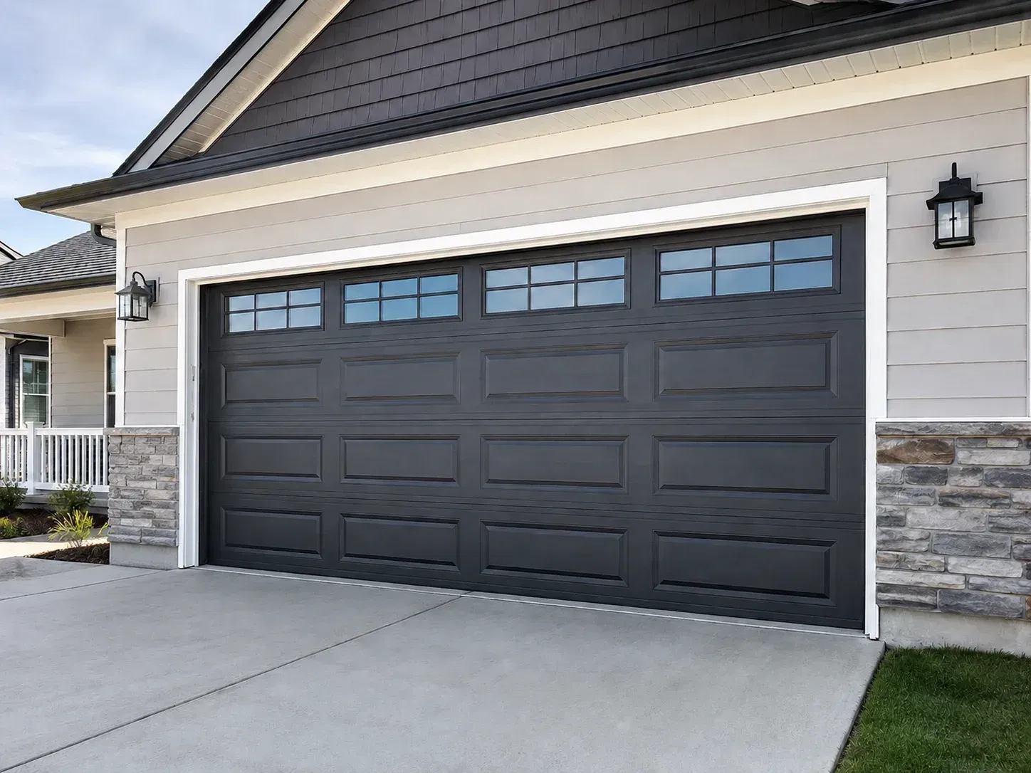 Black raised-panel garage door with top windows on a residential home in Roscoe IL