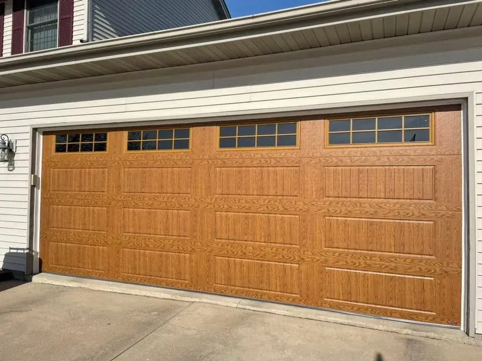 Golden oak wood-look garage door with top windows on a residential home in Roscoe IL