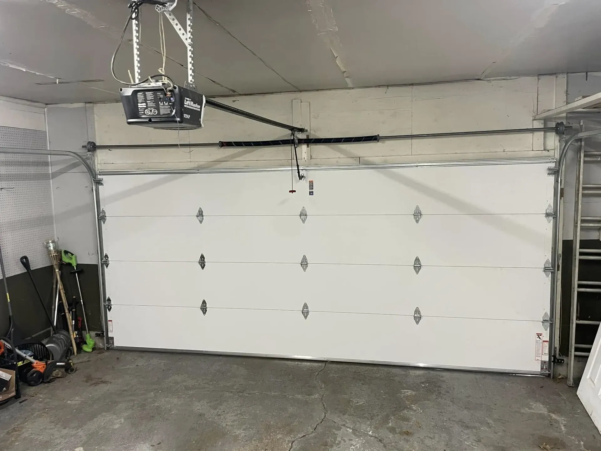 New residential garage door installation with opener inside a garage in Roscoe IL