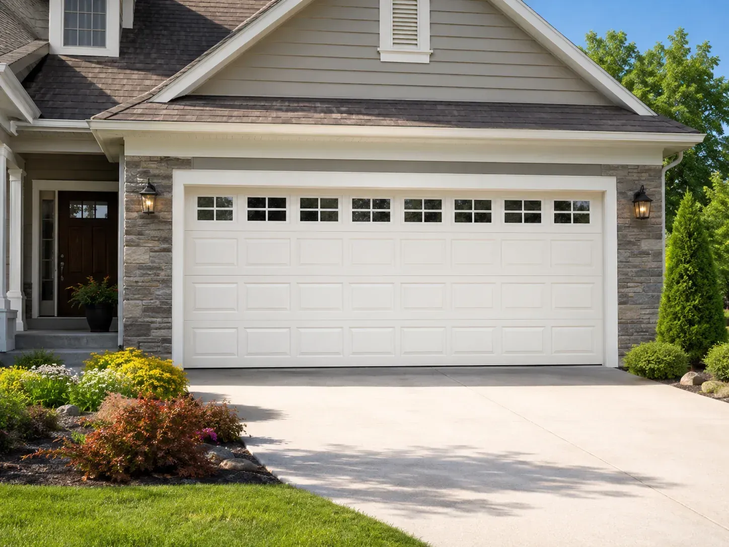 Vinyl garage door with decorative top windows on a clean residential exterior
