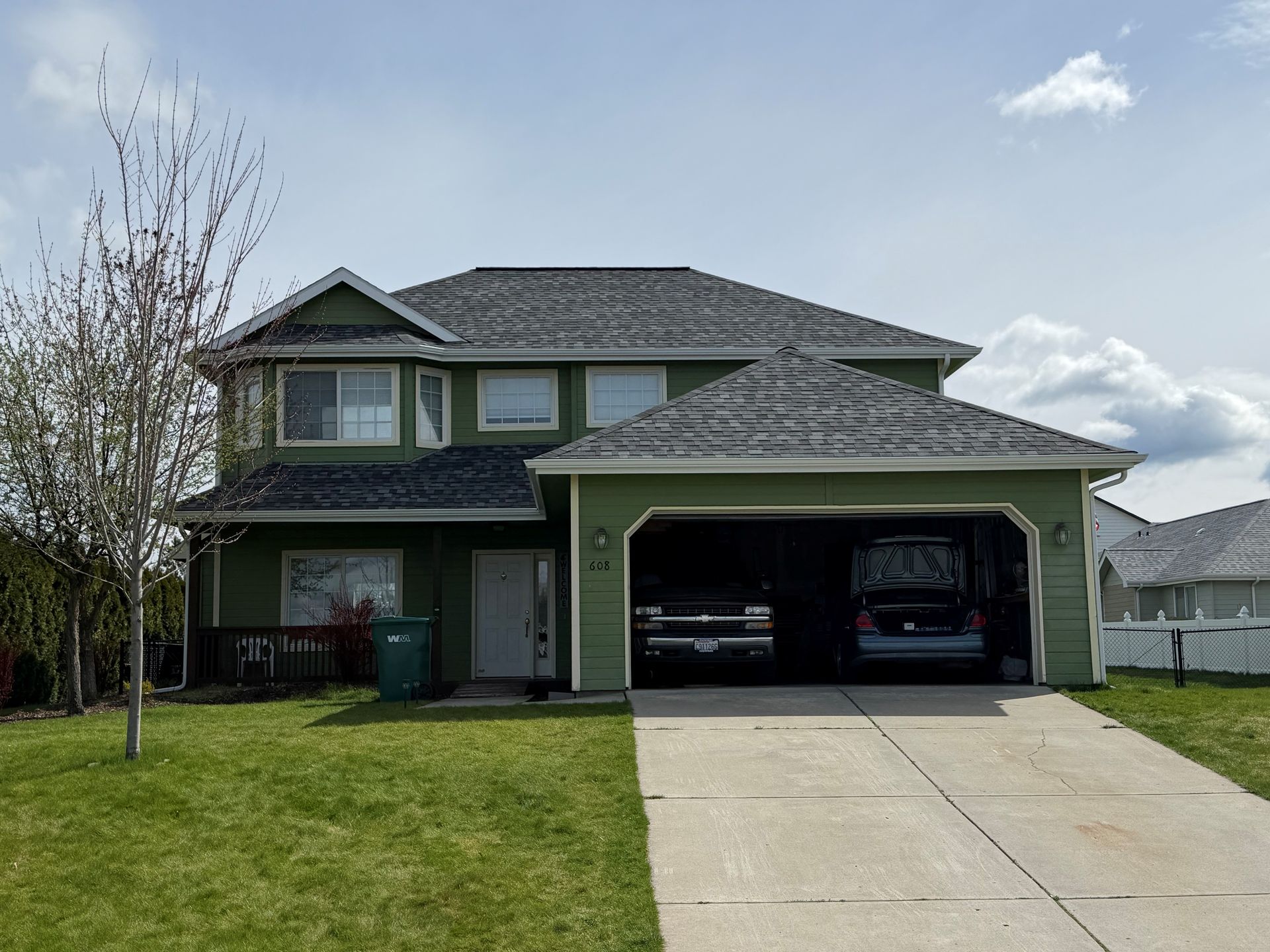 Three white dormer windows on a gray shingled roof with trees in the background Three white dormer windows on a gray shingled roof with trees in the background