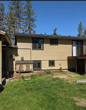 Person replacing pale green siding on a house exterior Person replacing pale green siding on a house exterior