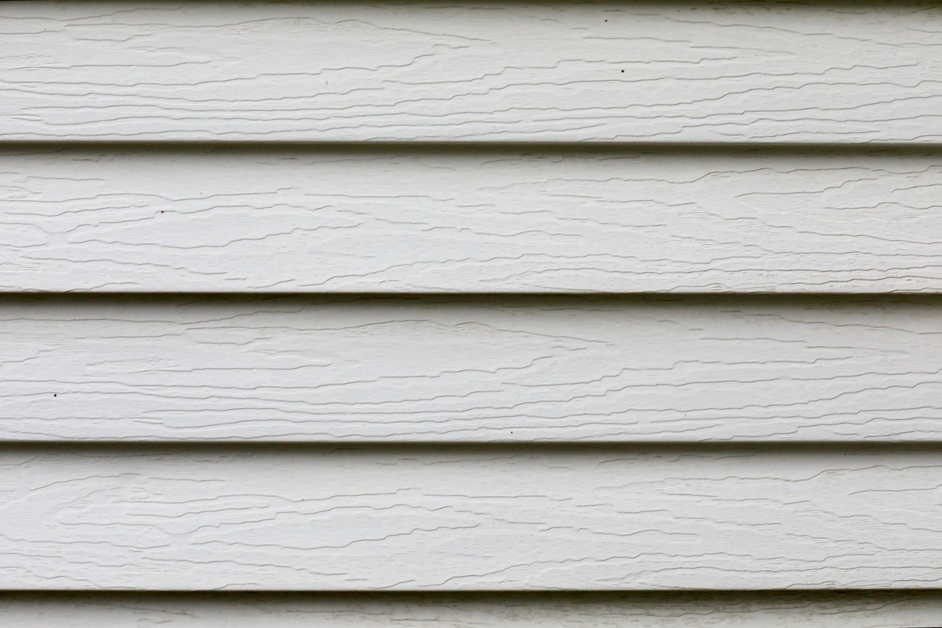 Horizontal white painted wood siding with dark gaps between boards.