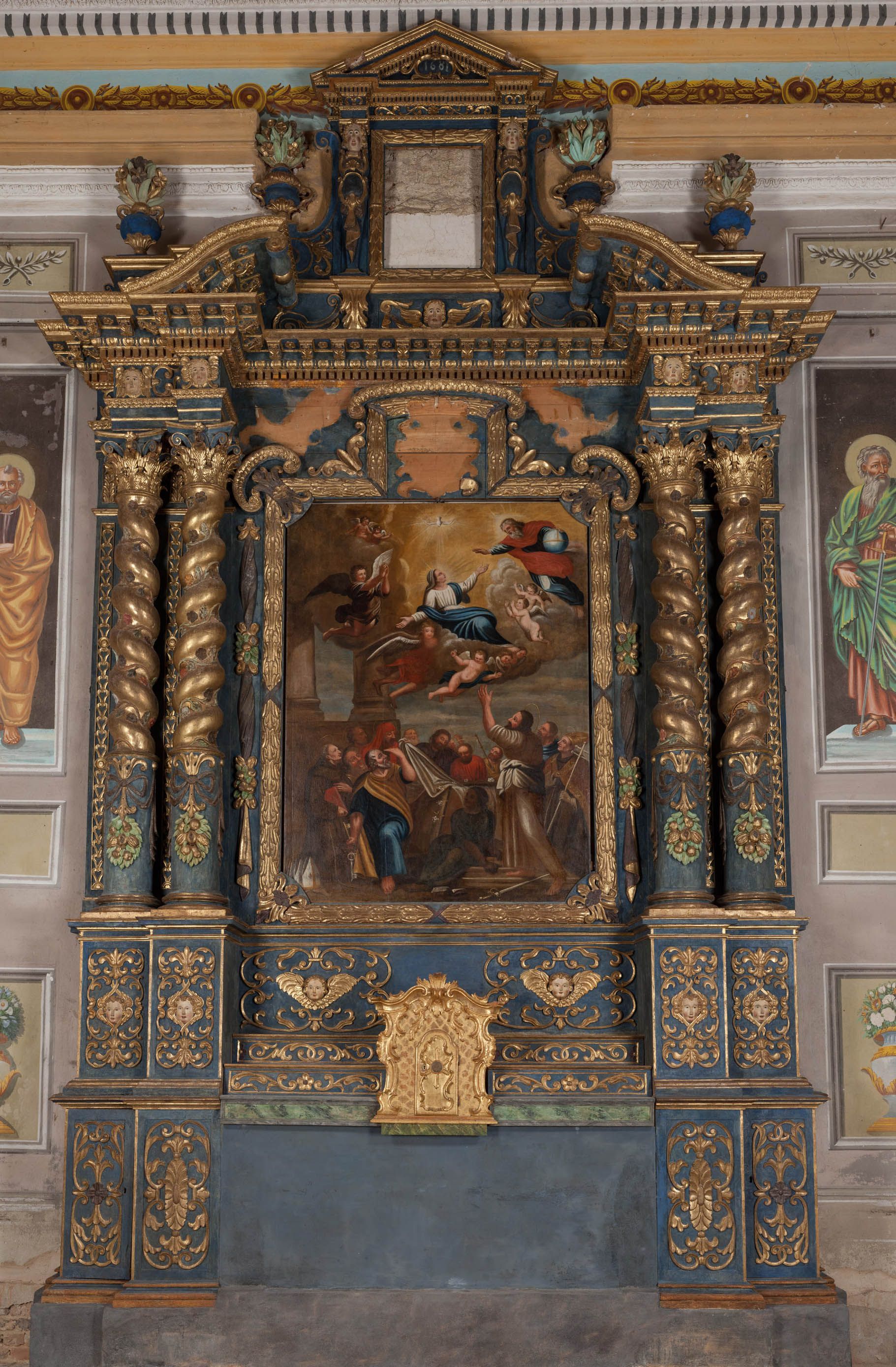 Altare religioso riccamente decorato e dorato con dipinto incorniciato e colonne scolpite all'interno di una chiesa.