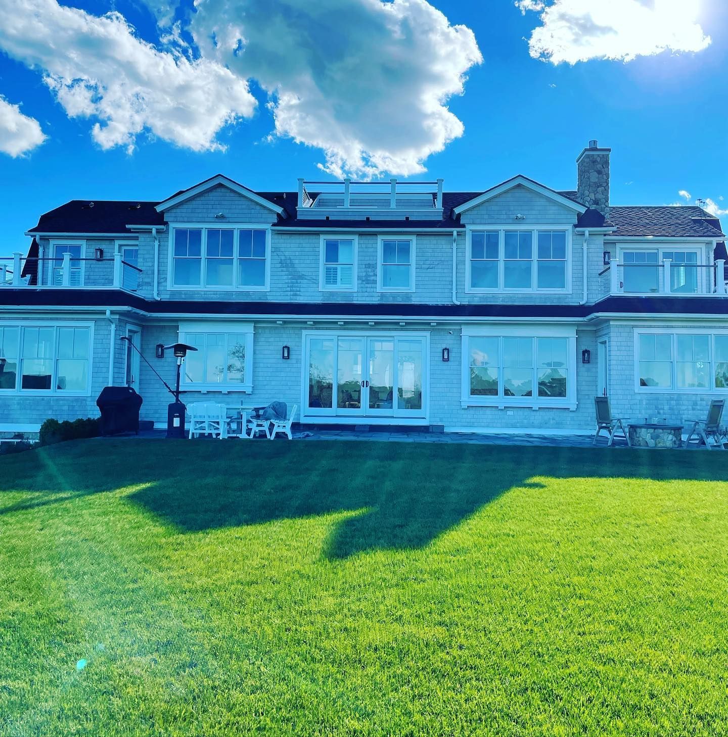 Clean window services for large waterfront home under blue sky | Window cleaning Cape Cod