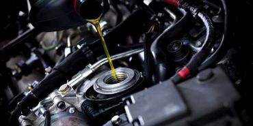 Oil being poured into a car engine.