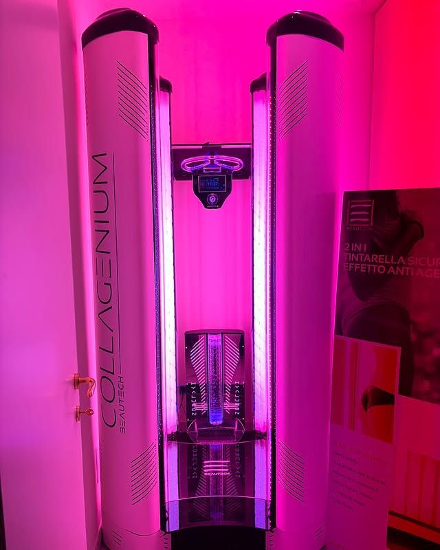 Due cabine abbronzanti alte, illuminate di rosa e con il marchio 