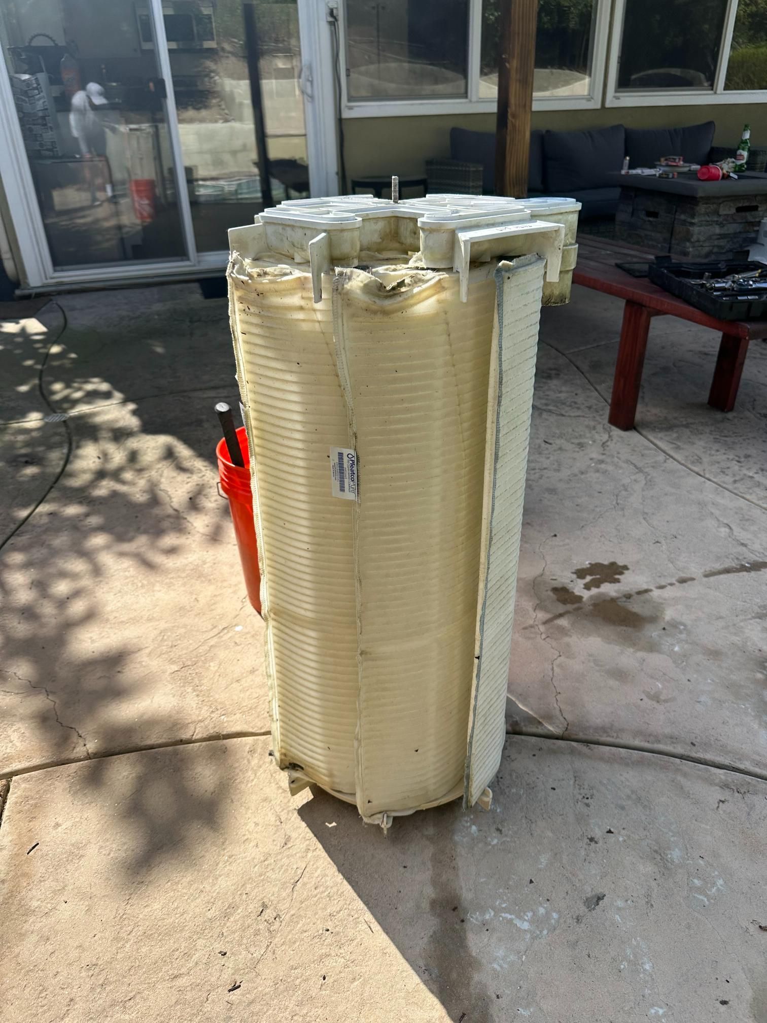 Large, beige, rectangular pool filter on a concrete patio.