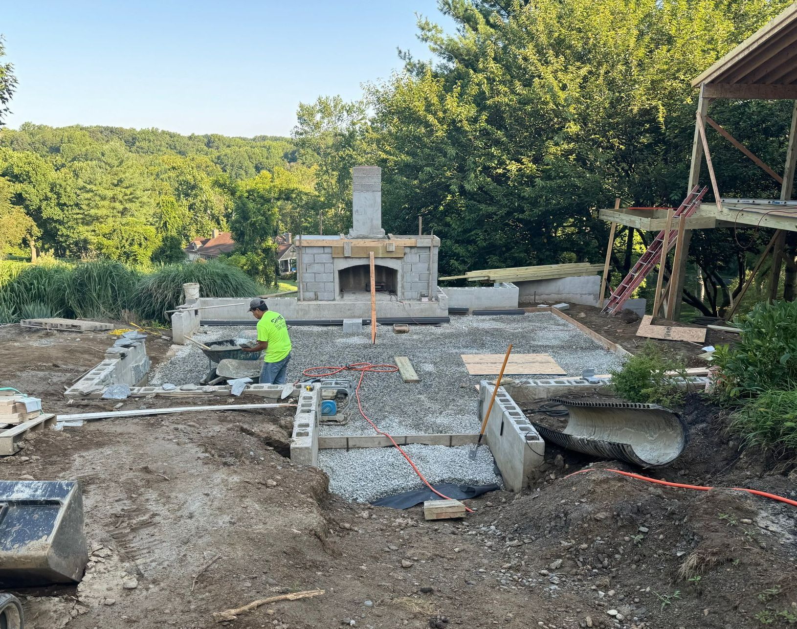 A man is laying bricks on a wall at a construction site.