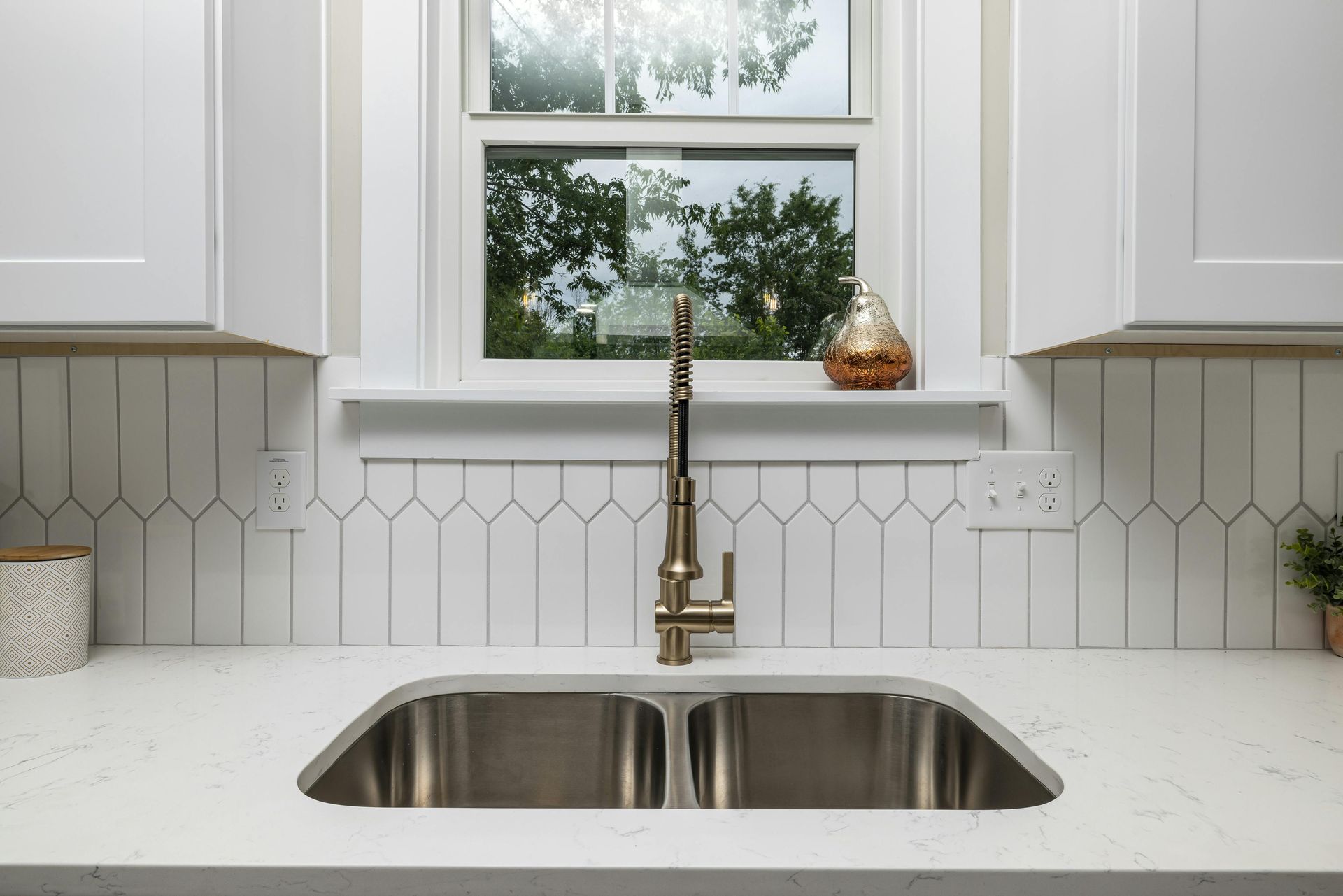 Kitchen sink and window with white cabinets and with new sink install by Gainesville Plumbing in North Georgia