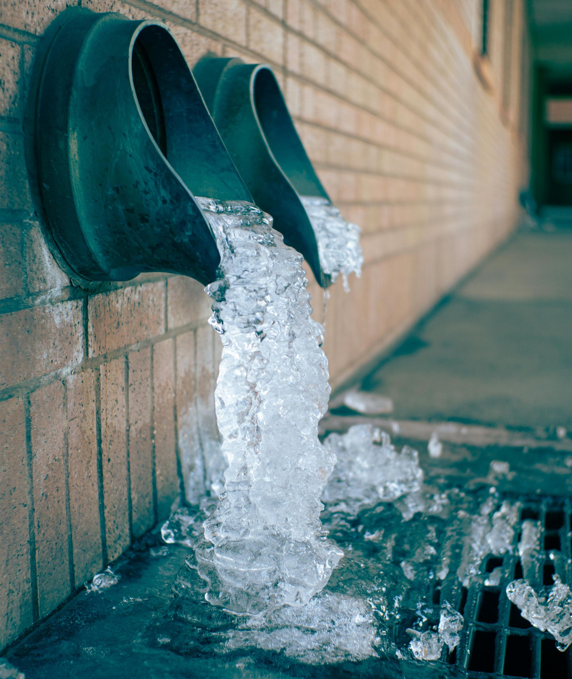 water pipe iced over from a pipe burst in Gainesville GA. Green pipes with ice coming out of side of building