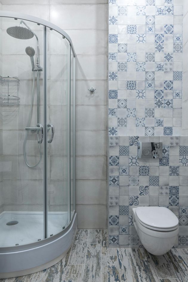 residential bathroom shower needing repairs with blue and white tile