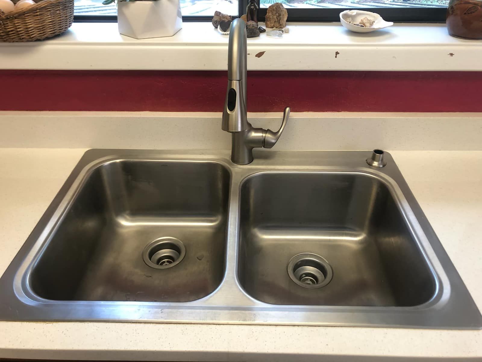 A kitchen sink with two sinks and a faucet