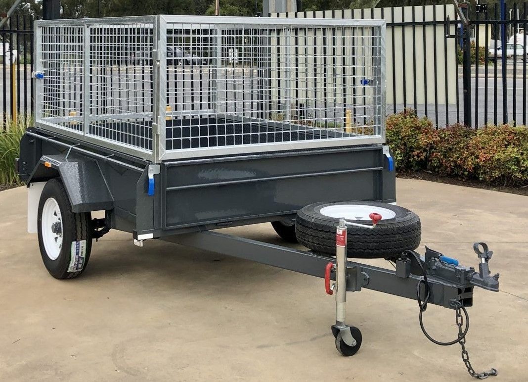 Gray trailer with a cage, spare tire, and hitch.
