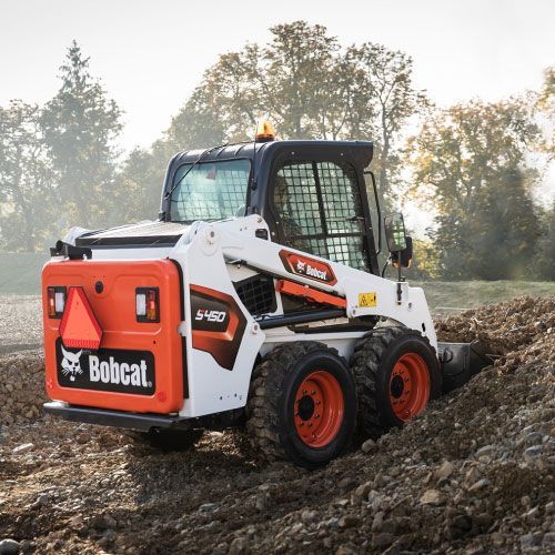 White Bobcat skid-steer loader with orange wheels and bucket.