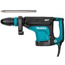 A jackhammer on a green case in a cluttered storage area with tools and shelving.