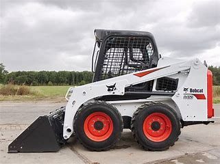 White Bobcat skid-steer loader with orange wheels and bucket.