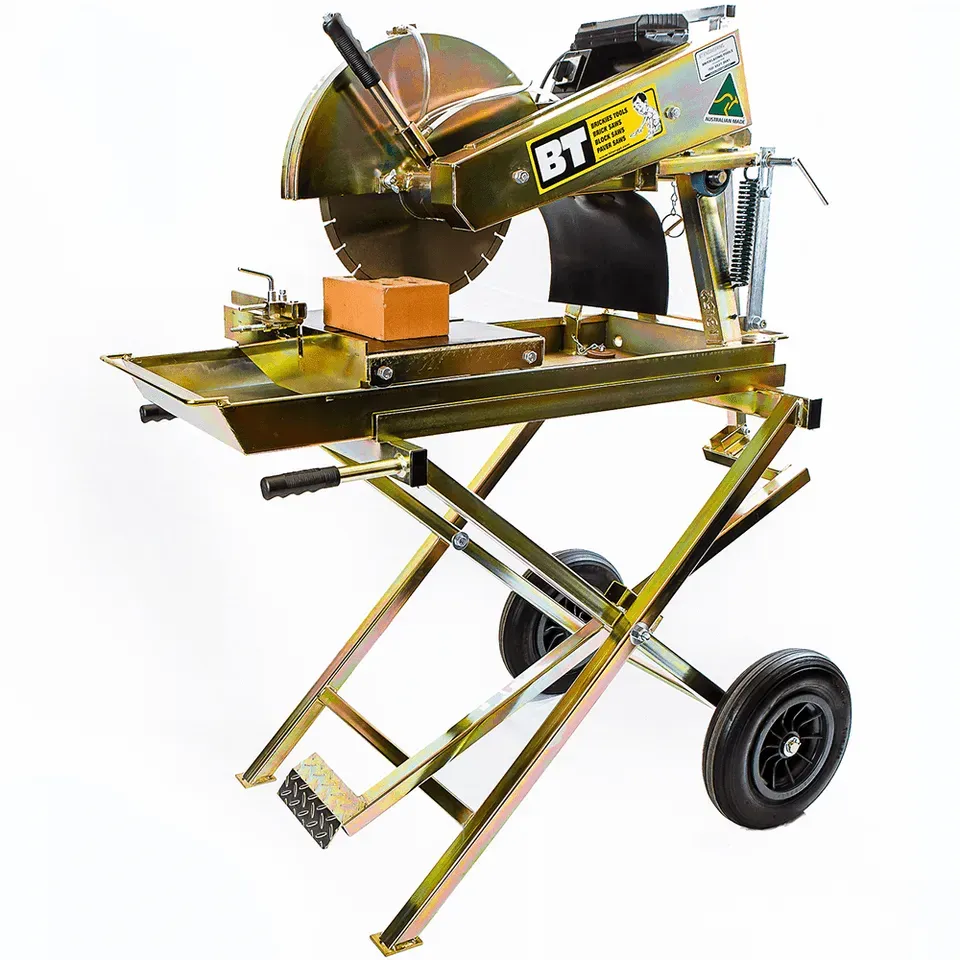 Brick saw with a cutting blade, cutting a brick on a yellow metal stand with wheels.