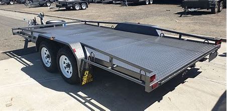 Galvanized steel box trailer with cage sides, spare tire, hitch, and wheels, outdoors.