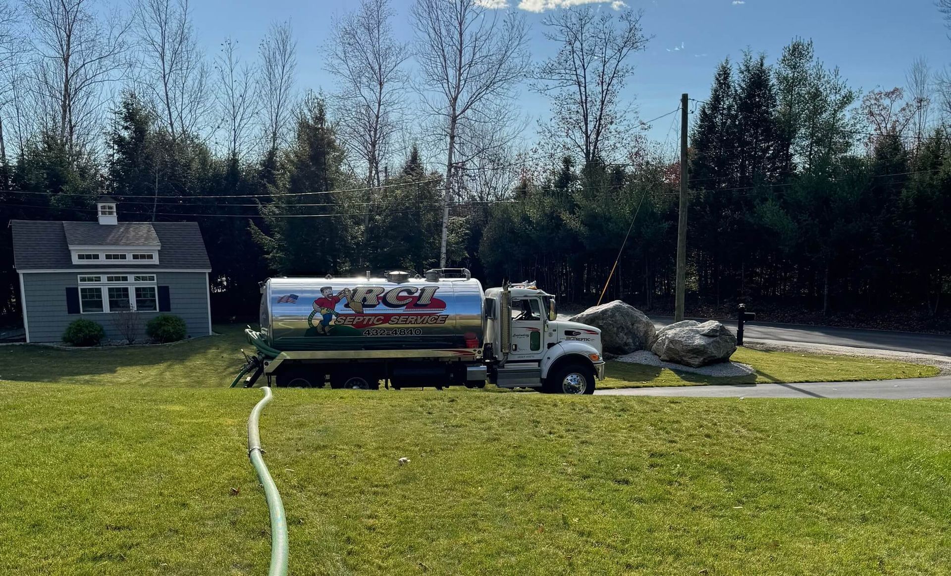 A septic service truck is parked in front of a building