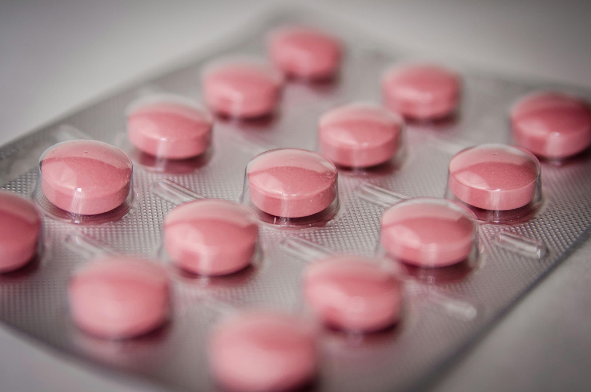 Pillole rosa in un blister, viste da vicino.