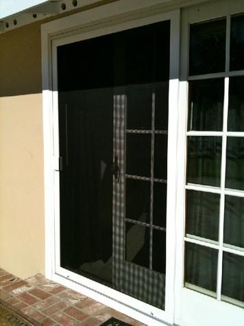 A white sliding glass door with a black screen