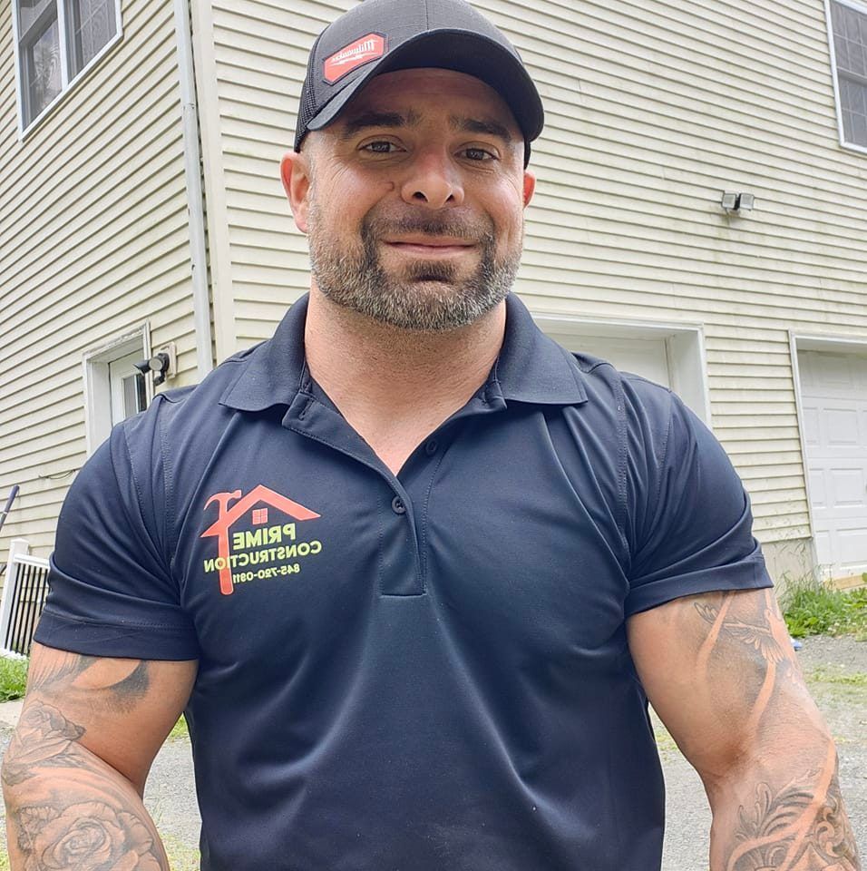 A man with a beard wearing a black shirt that says Prime Construction