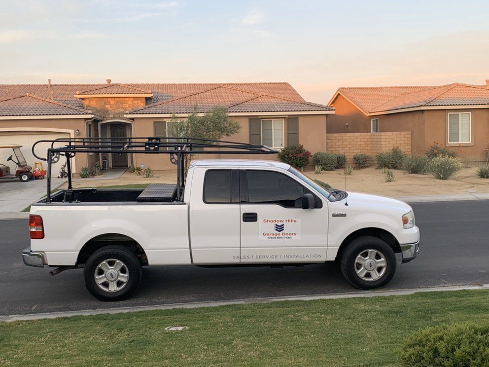 A white truck is parked in front of a house