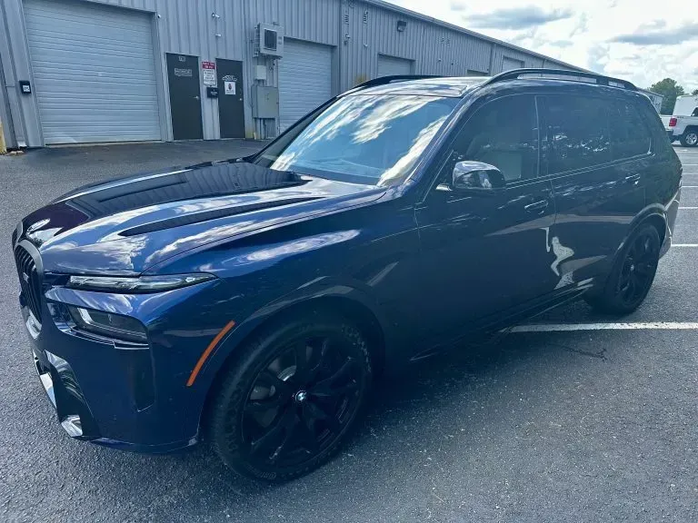 Dark blue SUV parked outside a warehouse on a sunny day