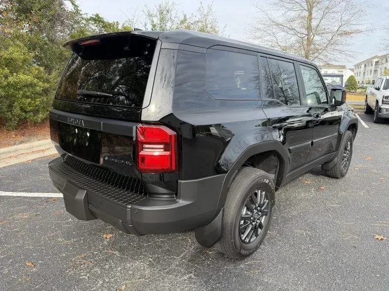 Black SUV parked on a street, rear three-quarter view, with tinted windows and red taillights.