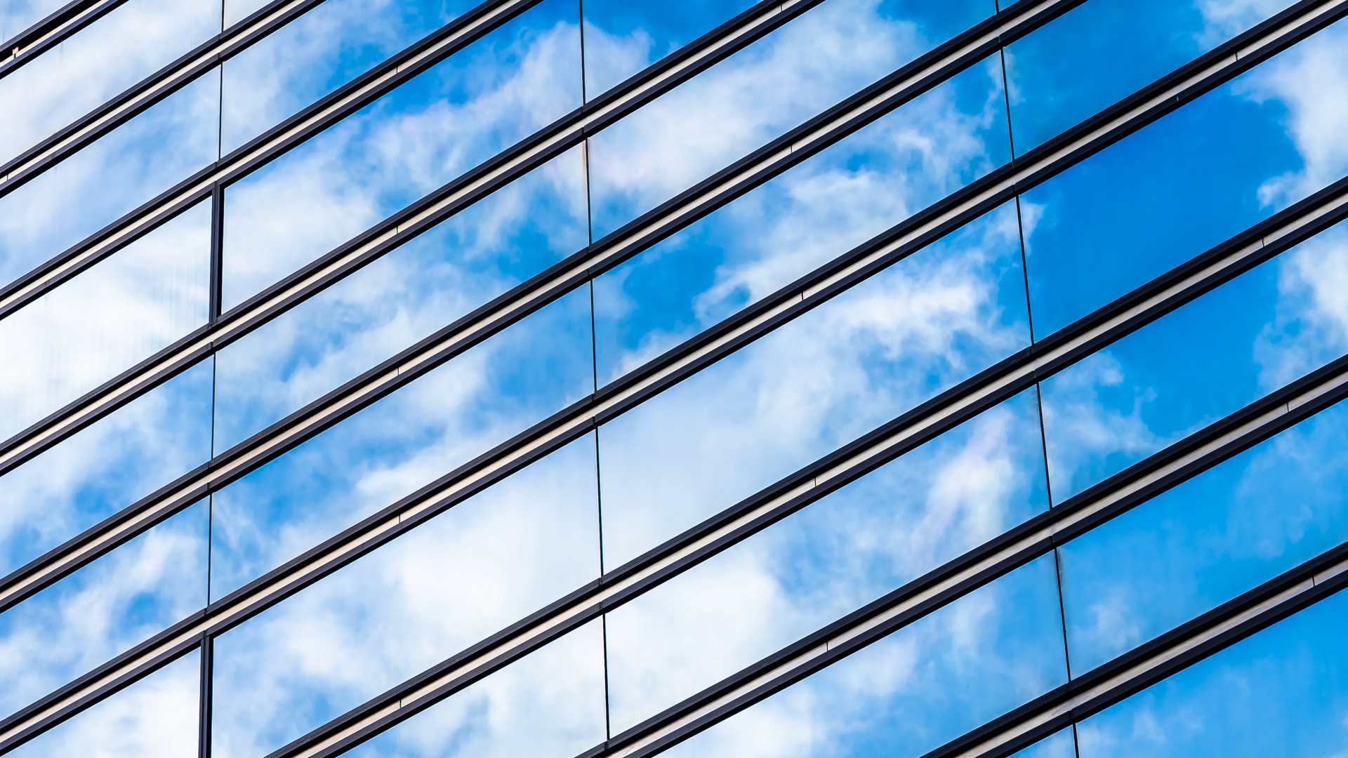 Diagonal metal cables against a blue sky with white clouds